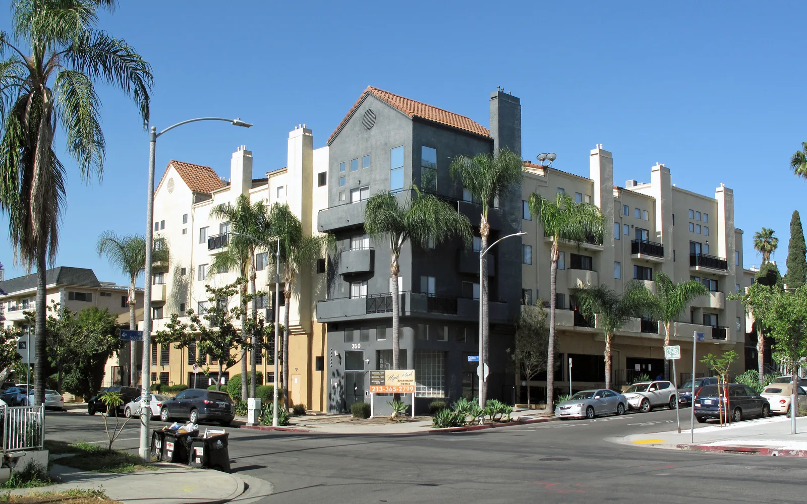 A residential neighborhood in Wilshire Center, Los Angeles, showing apartment buildings with balconies on a clear day